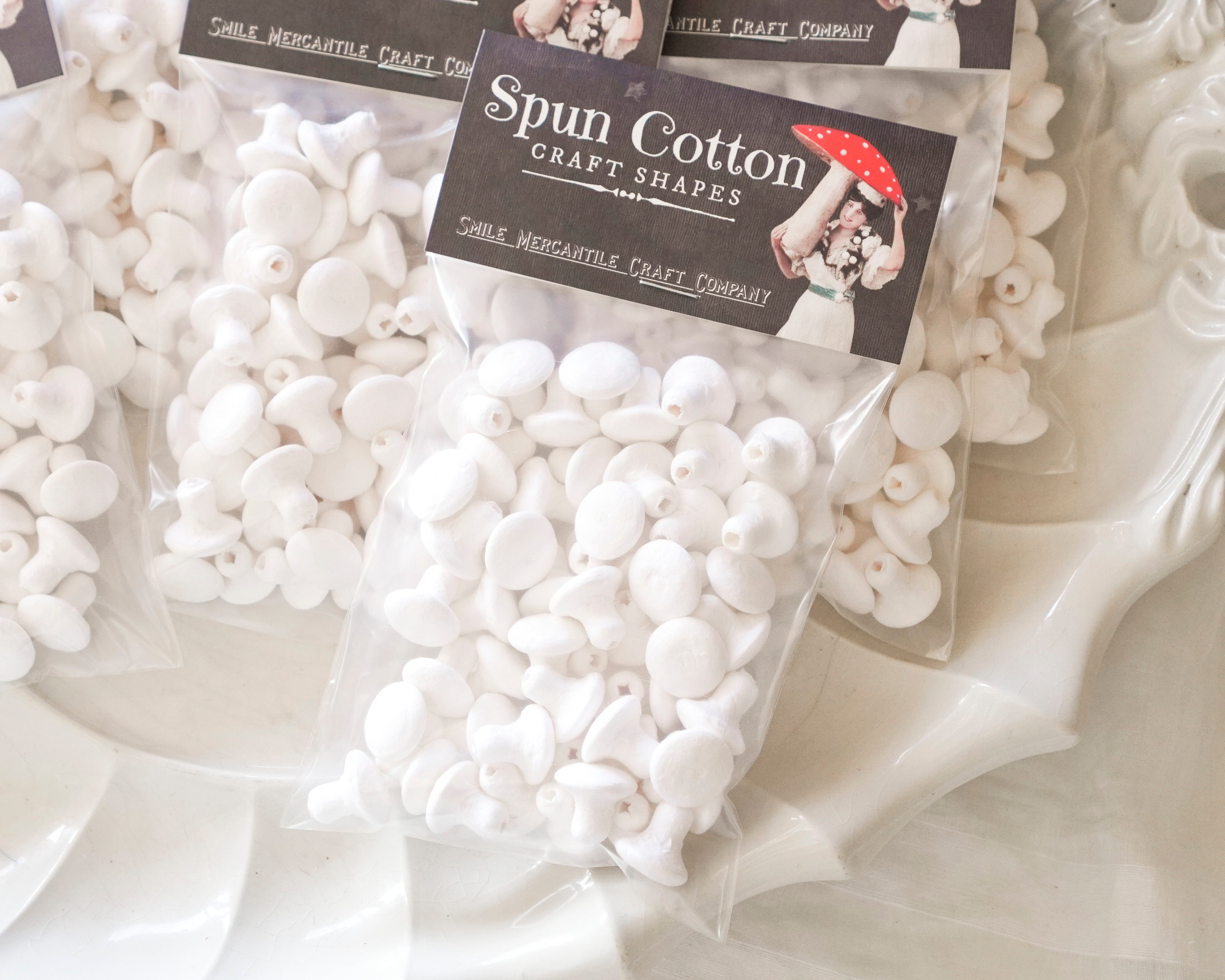 A pack of spun cotton mushrooms on a white surface.