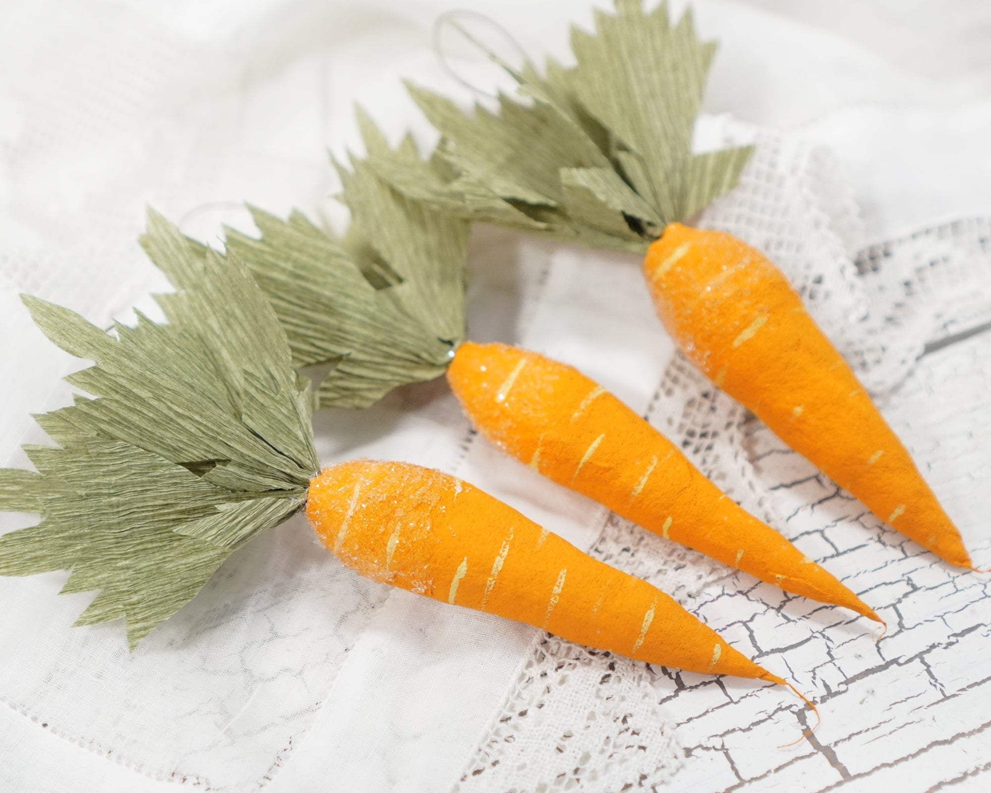 Spun cotton carrot ornaments on a white background
