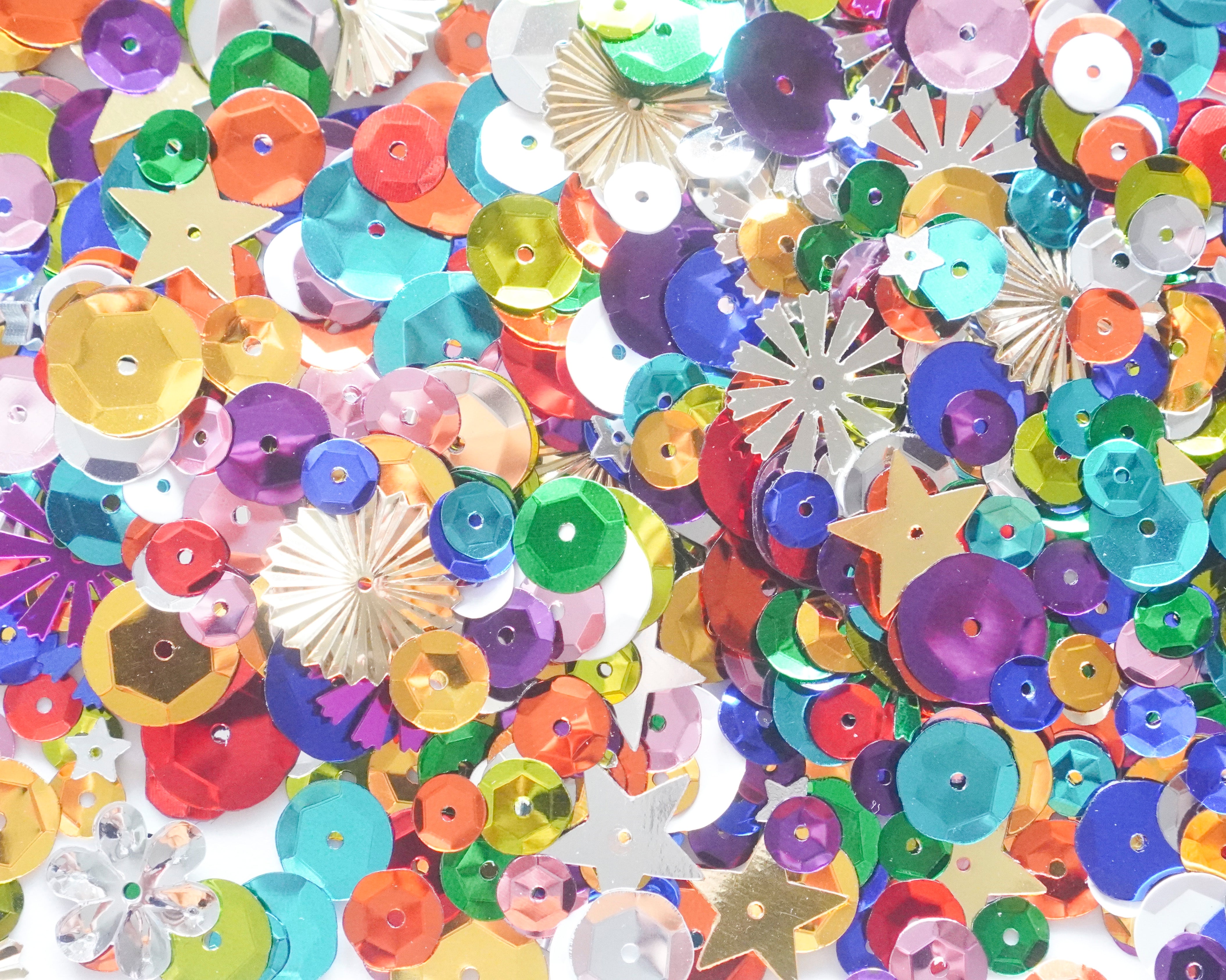 Assorted colorful sequins on a white background