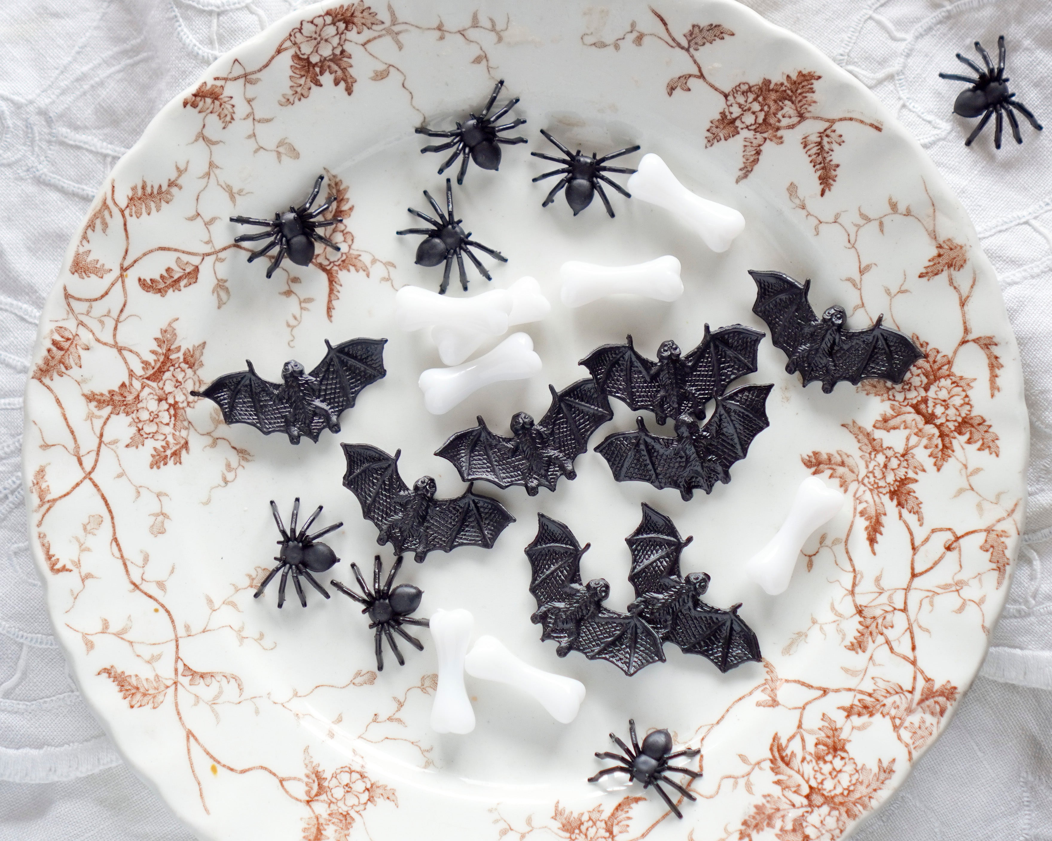 Mixed Halloween miniatures: Spiders, Bats, and Bones arranged on a plate.