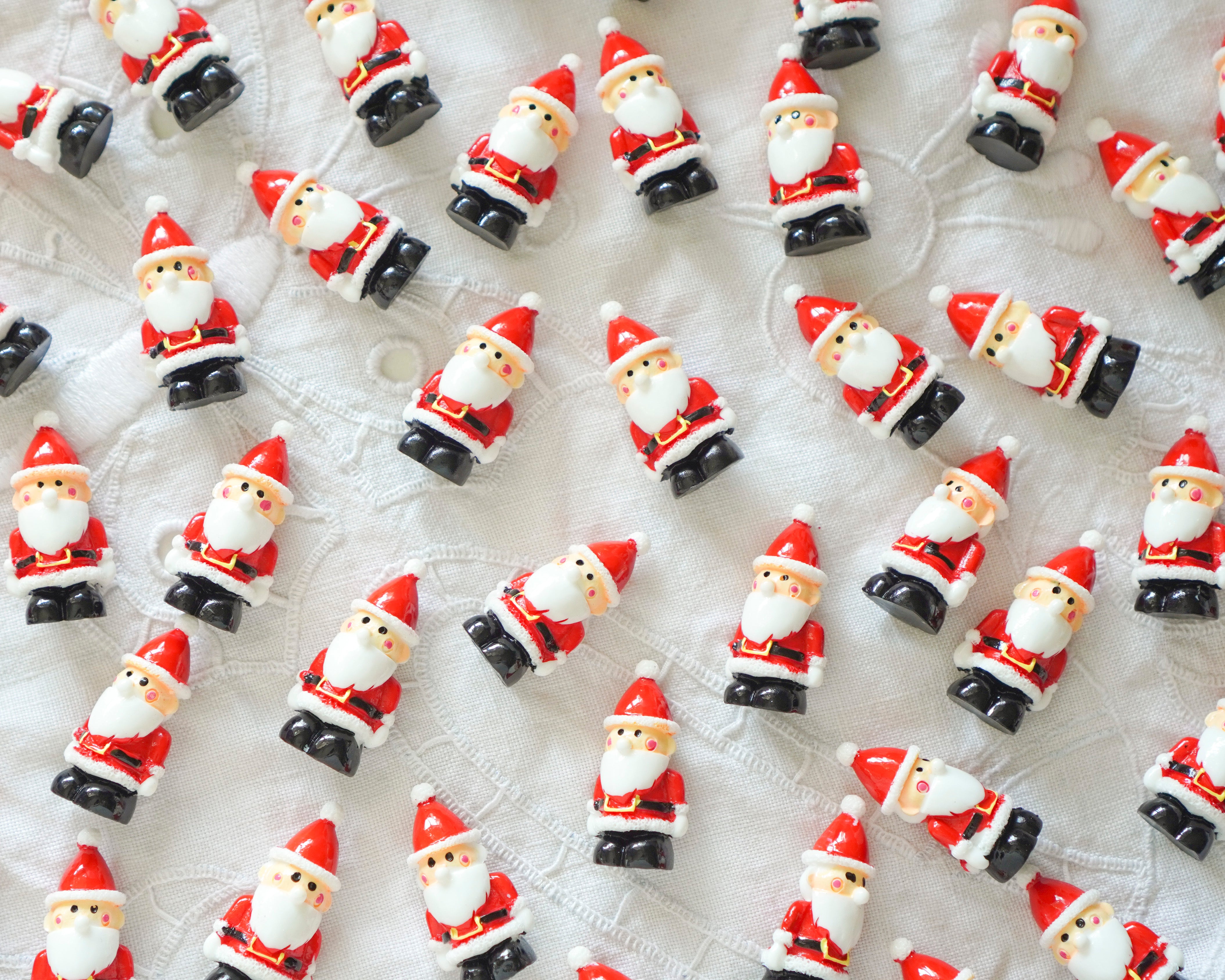 Small Santa Claus figurines on a textured surface