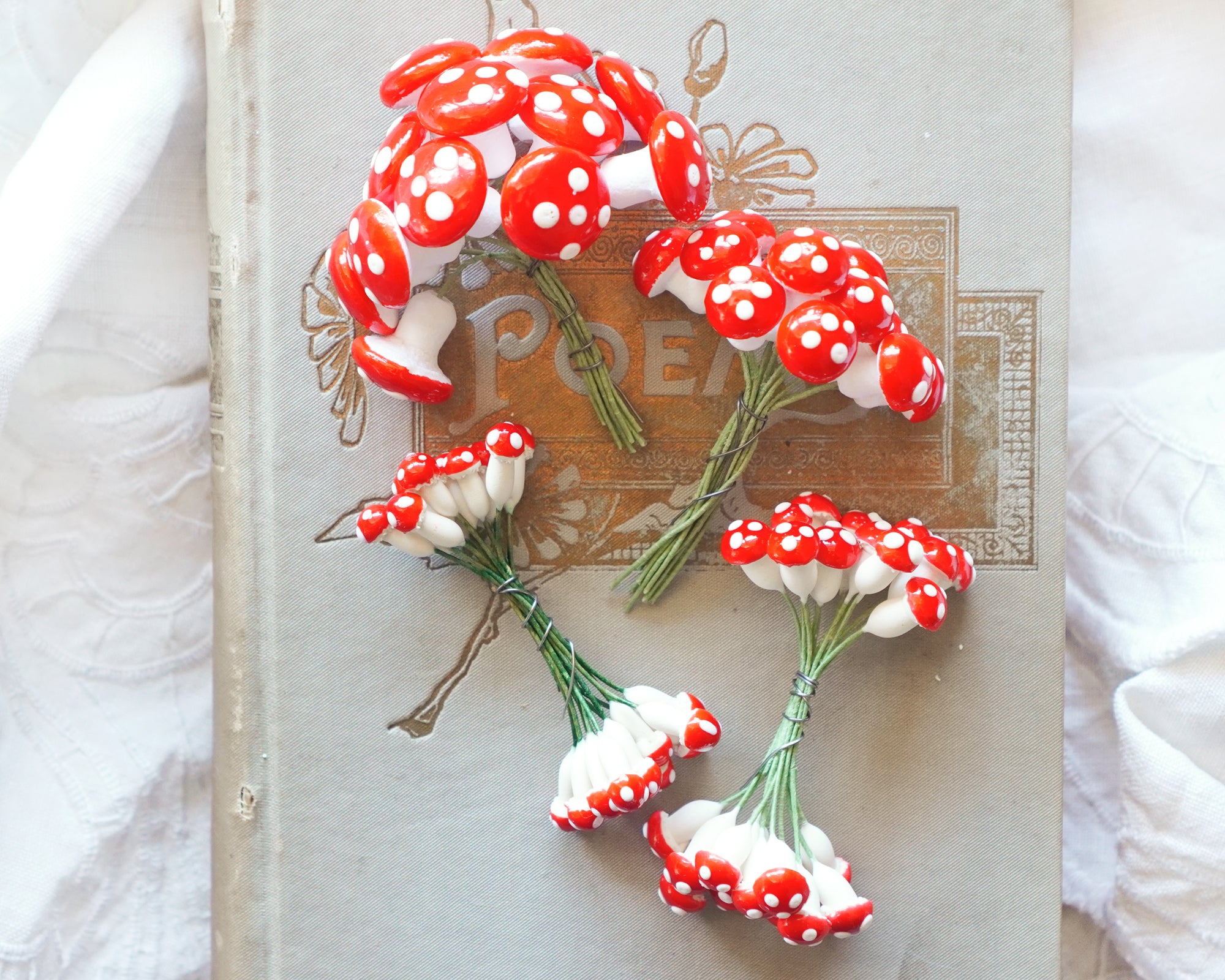 Red and white mushroom-shaped decorations on a textured book.