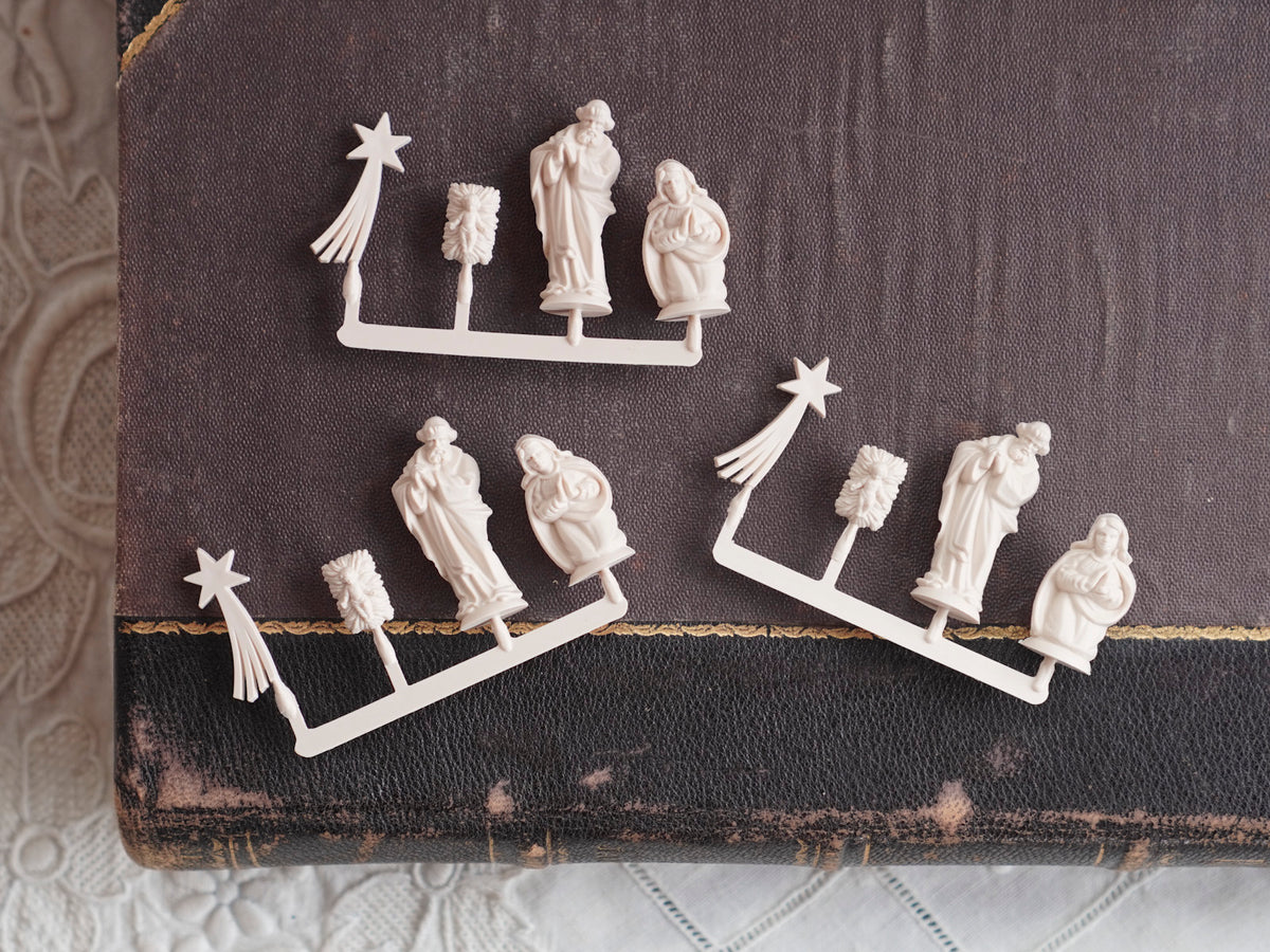 Miniature German Nativity figures displayed on a book.